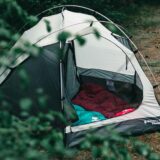 empty camping tent with sleepig bags in a forest