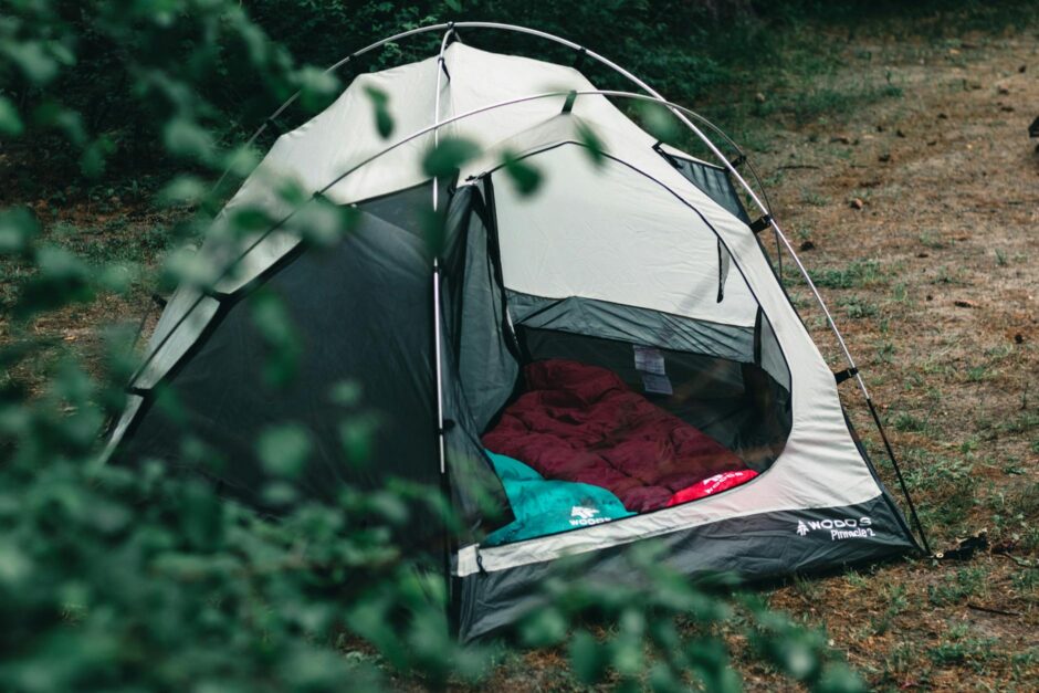 empty camping tent with sleepig bags in a forest