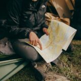 photo of woman sitting while pointing on world map