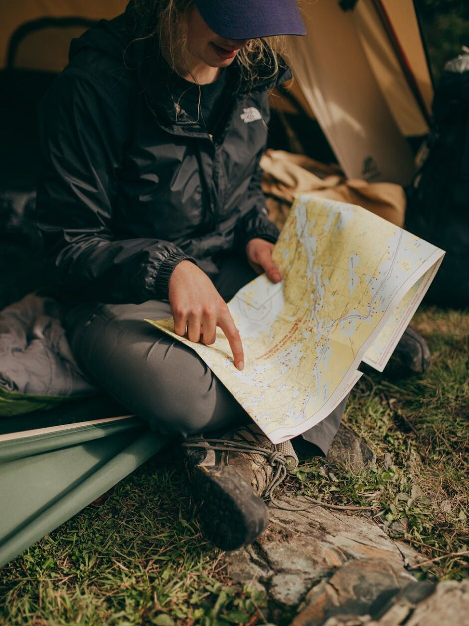 photo of woman sitting while pointing on world map