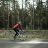 man riding black bicycle on roadside