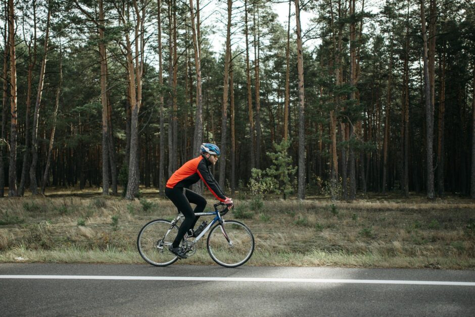 man riding black bicycle on roadside