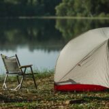 tent and portable chair on river shore in summer