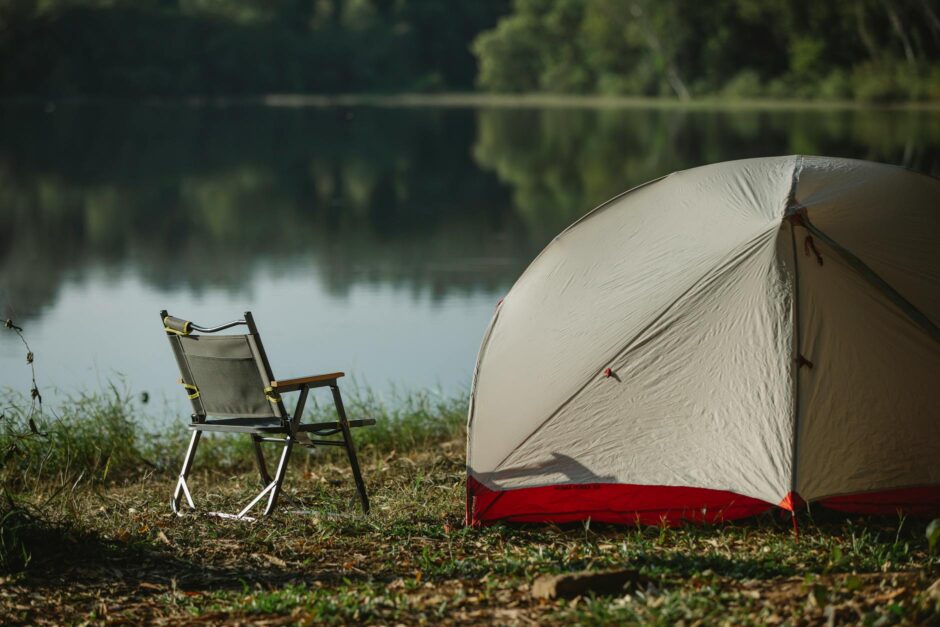 tent and portable chair on river shore in summer